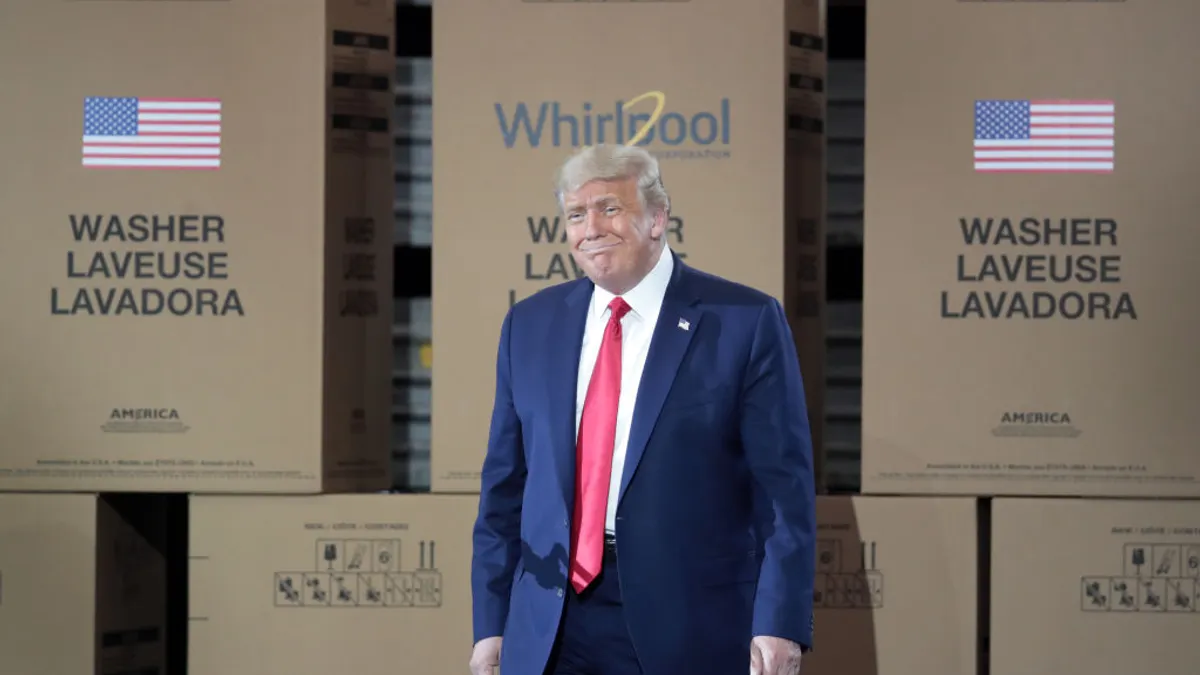 Donald Trump stands in front of cardboard boxes at a Whirlpool factory.