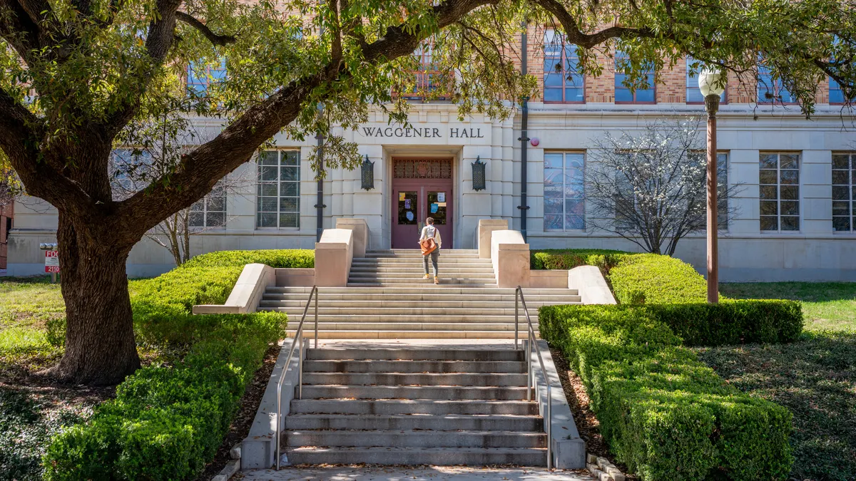 A student walks into a campus building at UT-Austin.