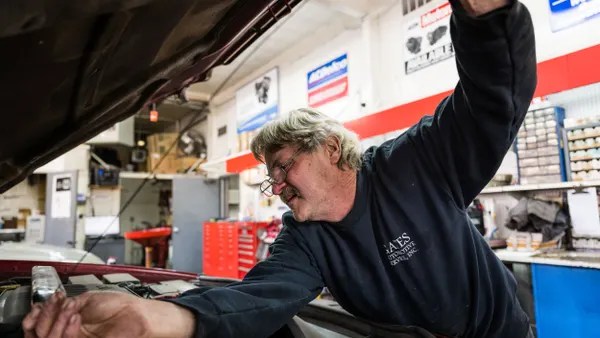 A mechanic checks an automobile's oil.