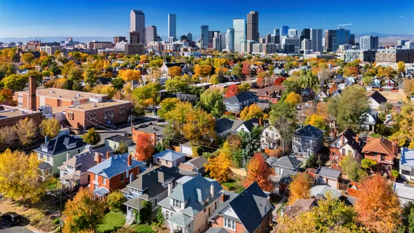 Aerial view of houses with a city skyline in the background.