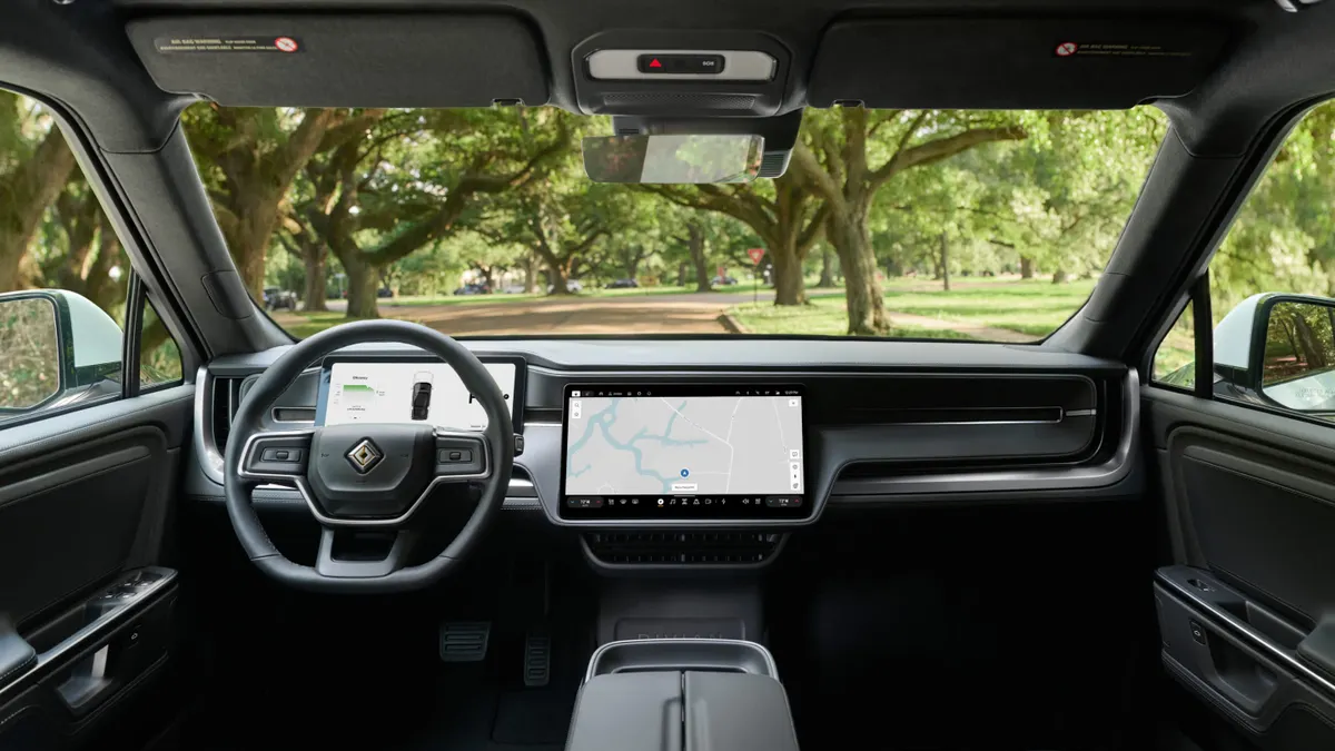 An interior view of the Rivian R1S SUV showing the dashboard and steering wheel.