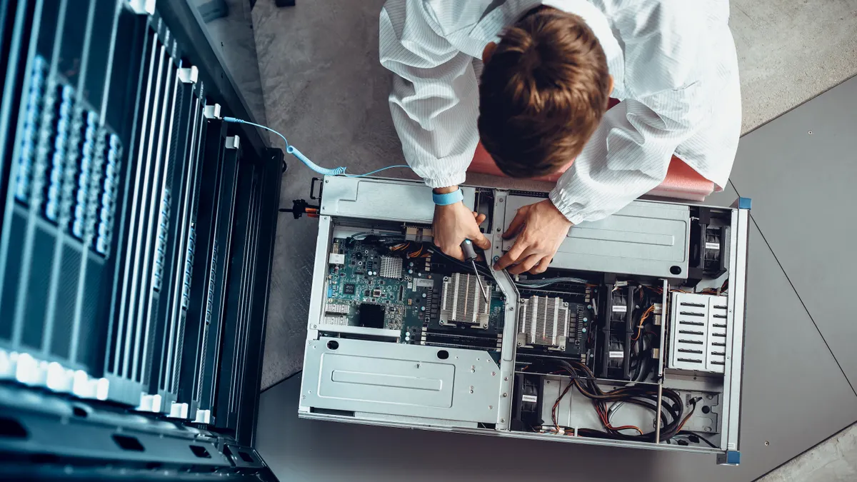 A picture from above of an IT Engineer Servicing Part of a Supercomputer.