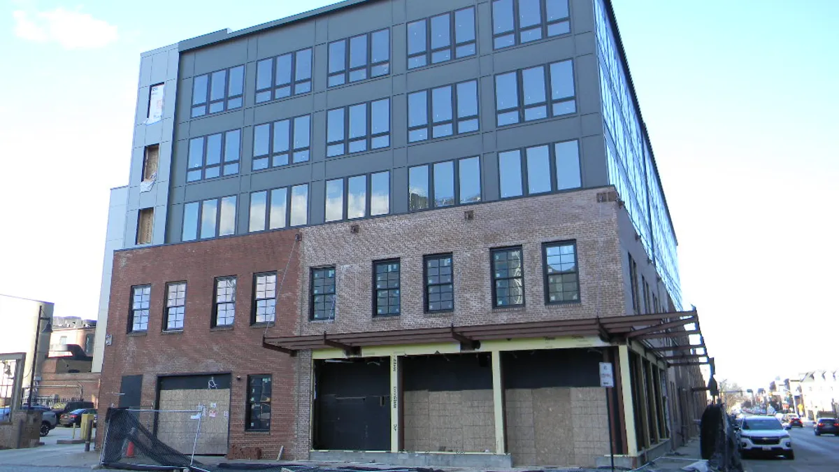 Mid-rise building with a warehouse exterior on the first two floors and modern glass above.