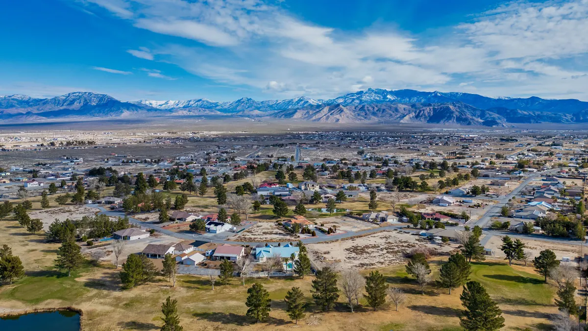 An overhead view of a Nevada town with mountains and sky in the distance