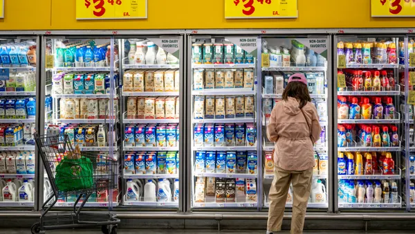 A woman stands in a supermarket.